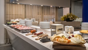 Un bufé con diversos alimentos y un jarrón decorativo con flores.
