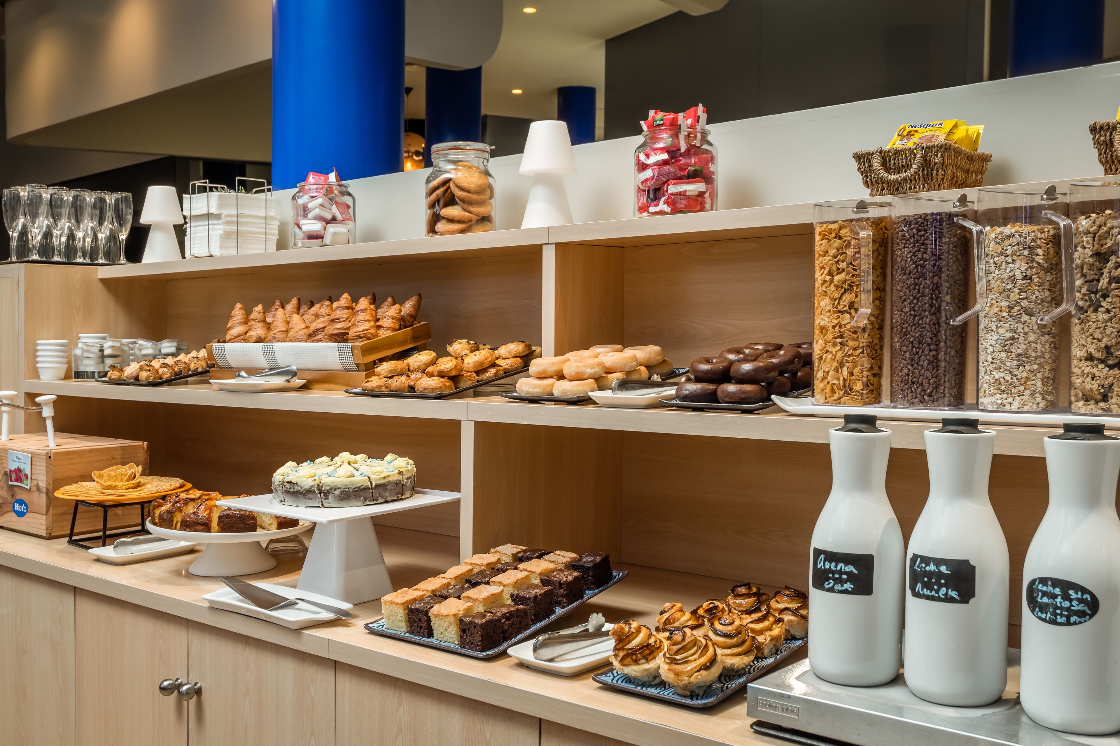 A buffet with various food items, including pastries, cakes, and beverages.