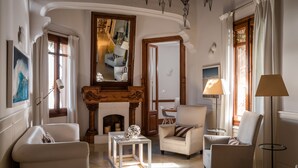 Un salón amplio con chimenea, asientos cómodos y un espejo grande.