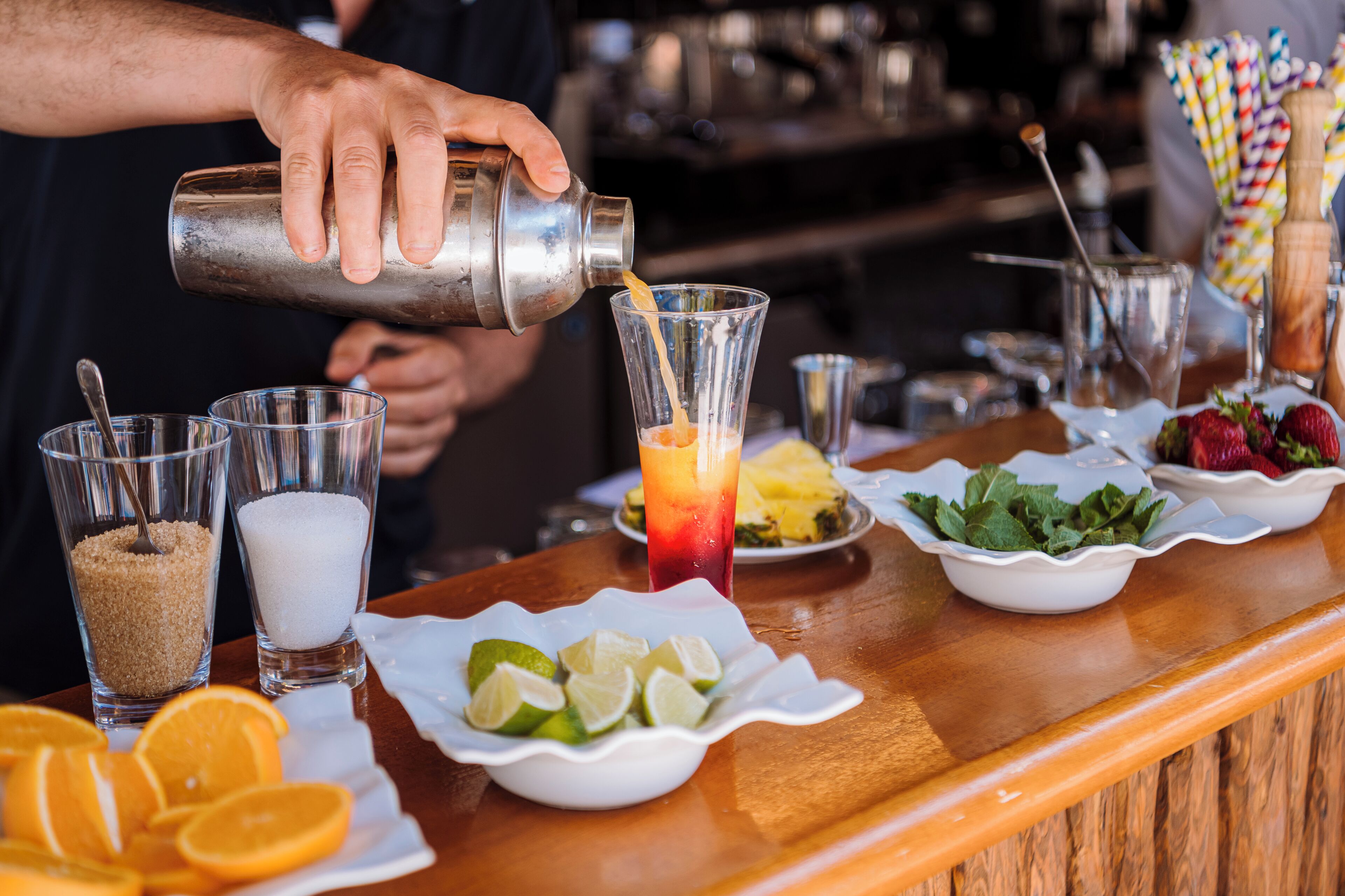 A bartender pouring a drink into a glass.
