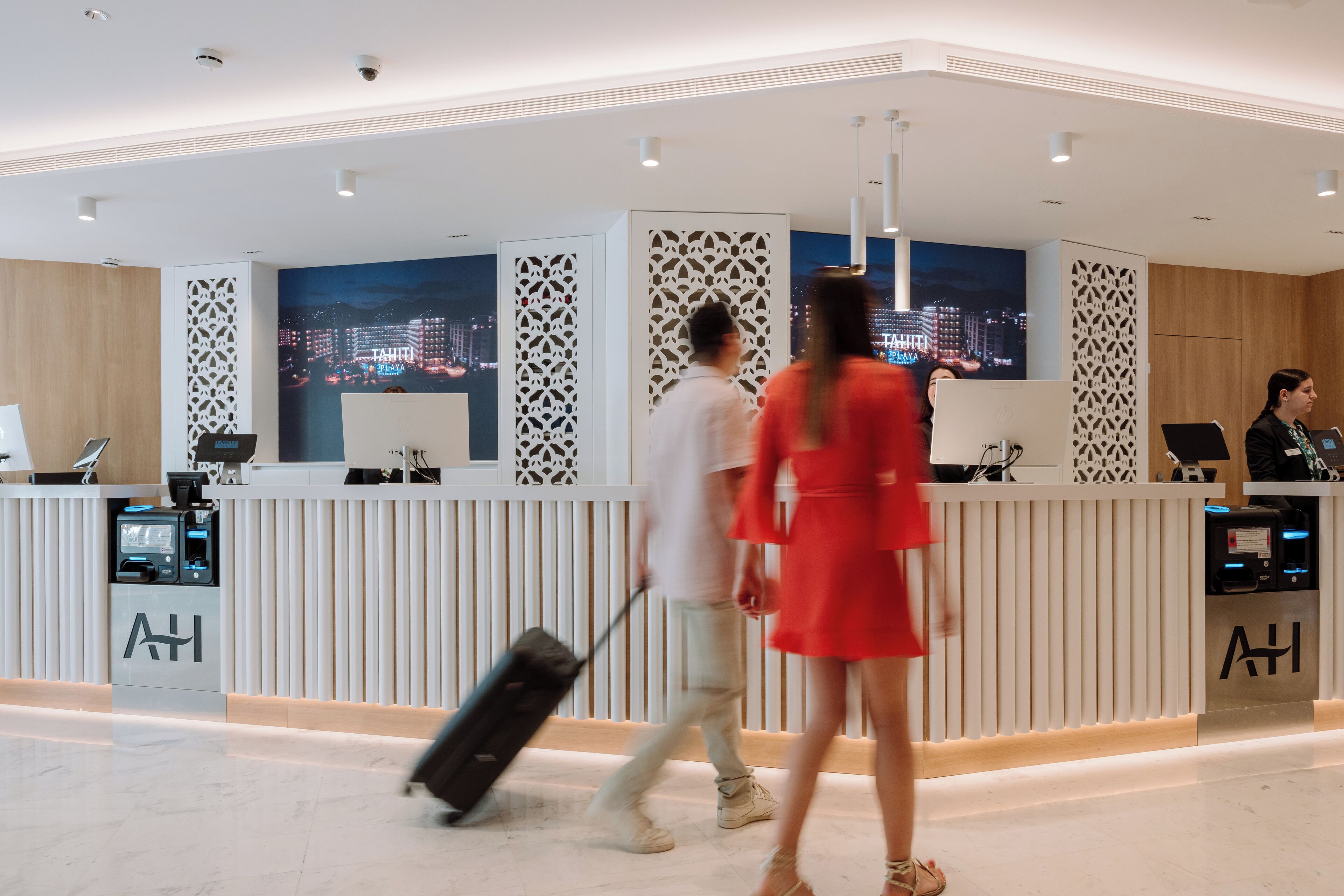 Ein moderner Hotel-Empfangsbereich mit Blick auf die Stadt, eine Rezeption und ein Check-in-Schalter.