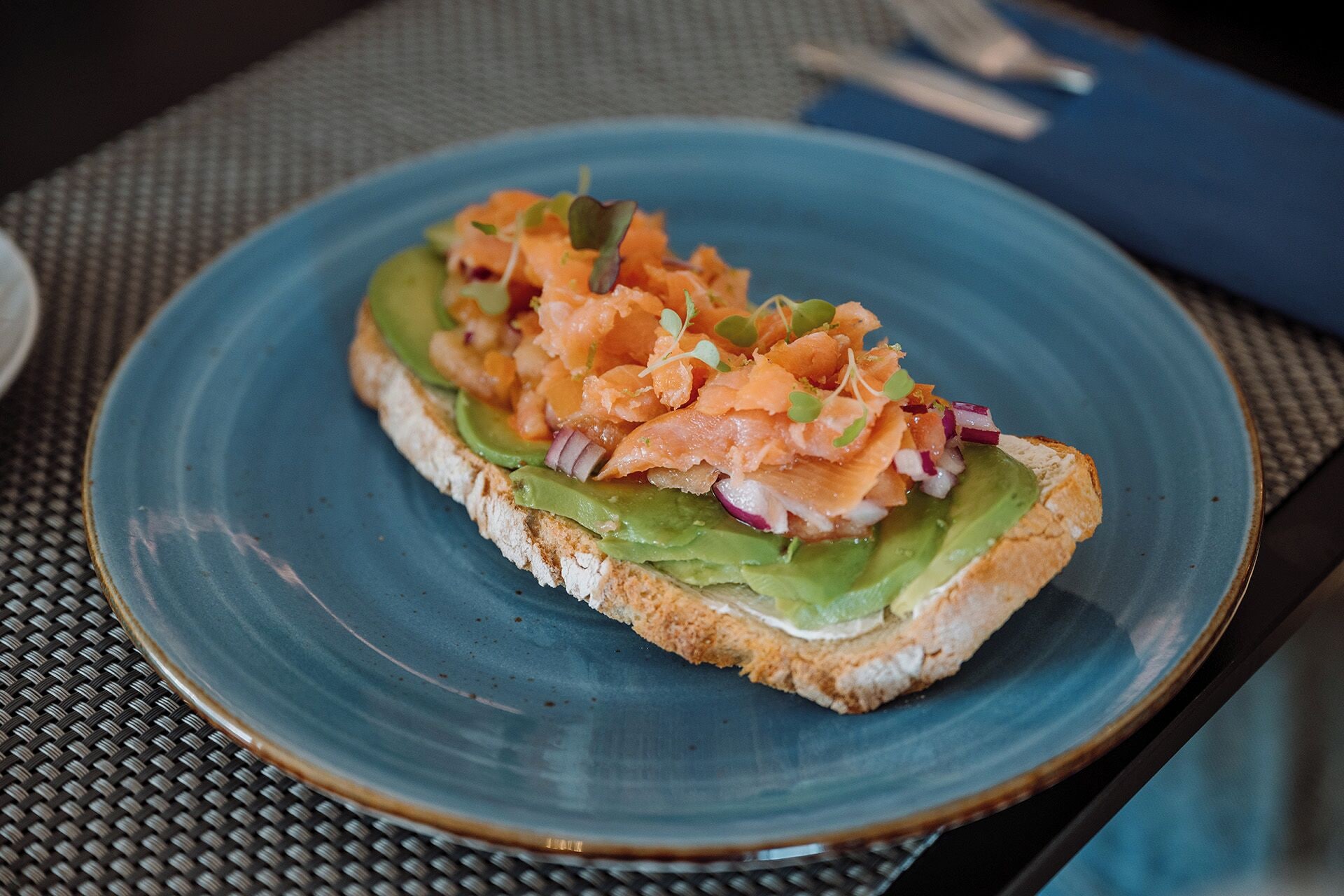 A plate with a sandwich on a blue plate.