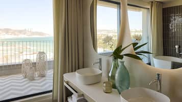 A modern bathroom with a large window, two sinks, and a large mirror.