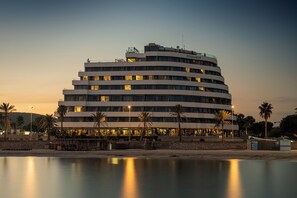 A multi-story hotel with a curved facade, located near a waterfront. - ME Sitges Terramar (Sitges)