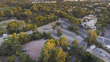 An aerial view of a residential area with a parking lot, trees, and buildings.