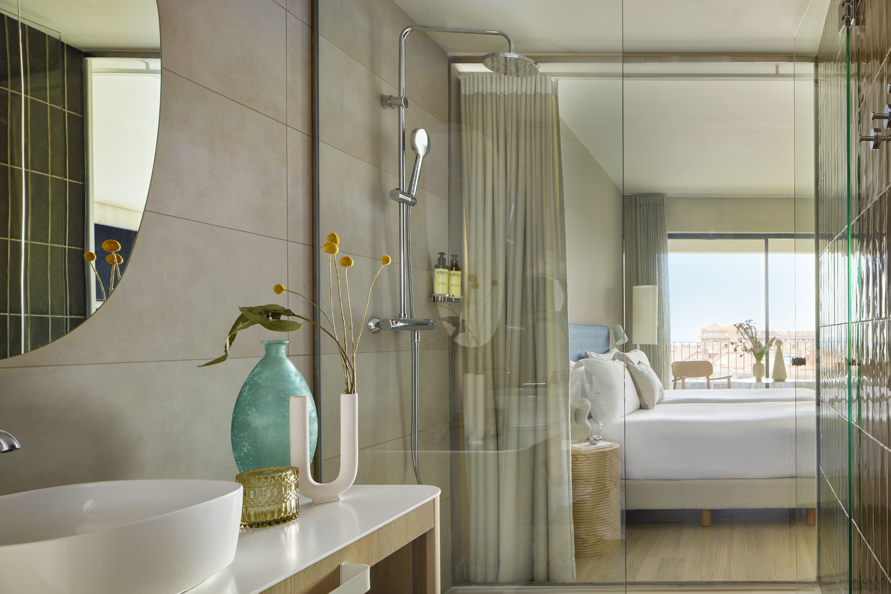 Un baño moderno con un espejo grande, un lavabo blanco y una zona de ducha.