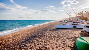 Una playa con barcos y cielo despejado.