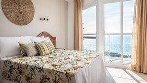 Una habitación de hotel con una cama, un tapiz circular grande y un balcón con cortinas.
