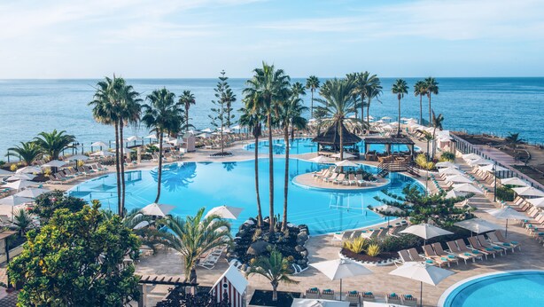 A resort with multiple swimming pools, palm trees, and lounge areas with umbrellas. - Iberostar Selection Anthelia (Adeje)