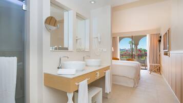 Un baño moderno con un espejo grande, dos lavamanos y una ducha.