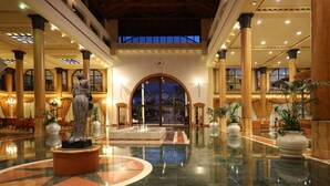 A spacious lobby with a large fountain, high ceilings, and classical columns. - Iberostar Selection Anthelia (Adeje)