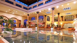A spacious lobby with a polished marble floor, large columns, and a bar area. - Iberostar Selection Anthelia (Adeje)