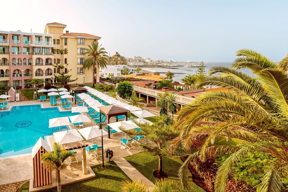Um resort com piscina, espreguiçadeiras e guarda-sóis.