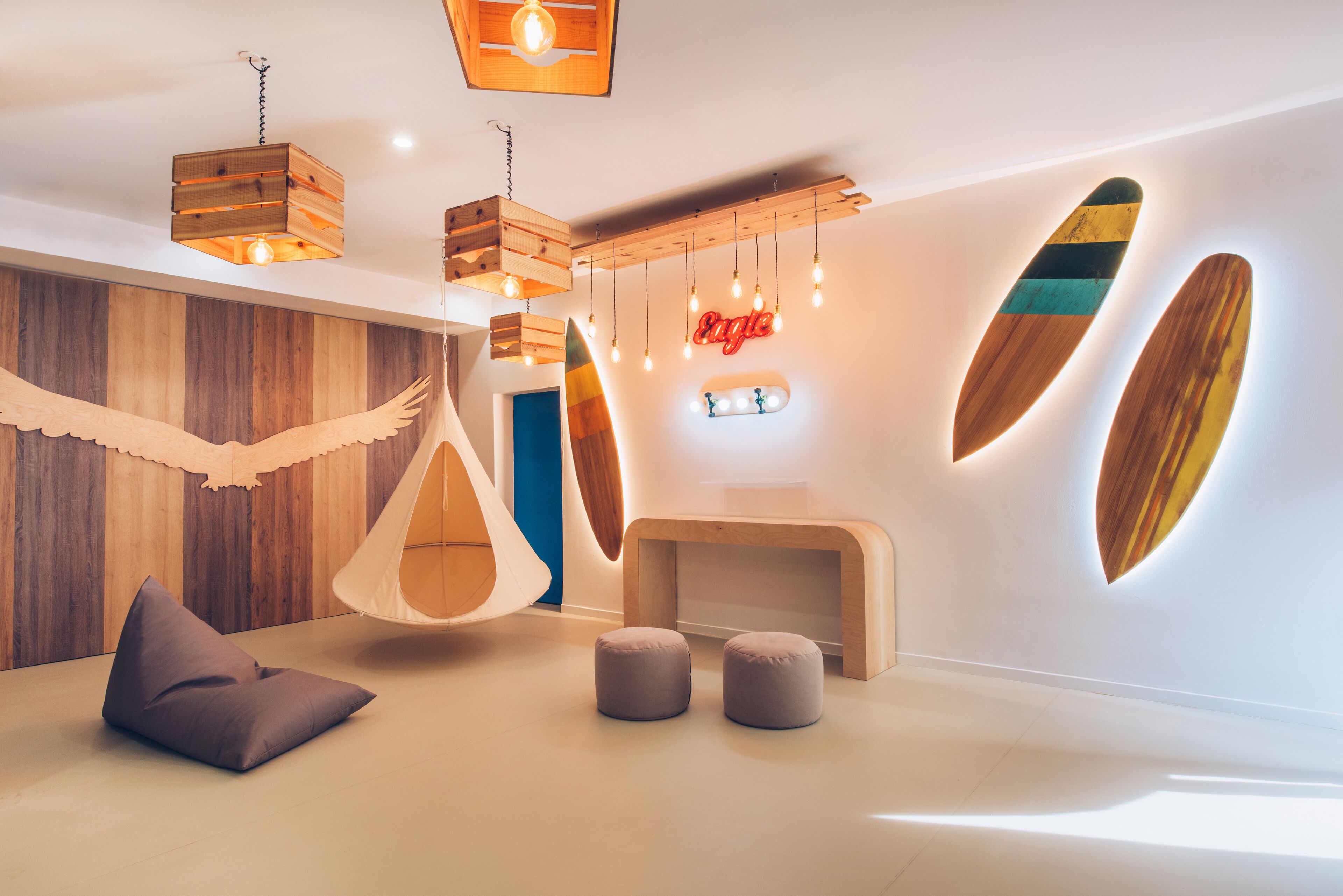 Un interno moderno con elementi in legno, lampade a sospensione e tavole da surf appese al muro.