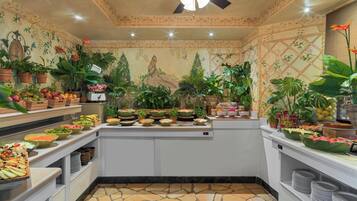 Un área de buffet con diferentes opciones de comida y un mural decorativo en la pared.