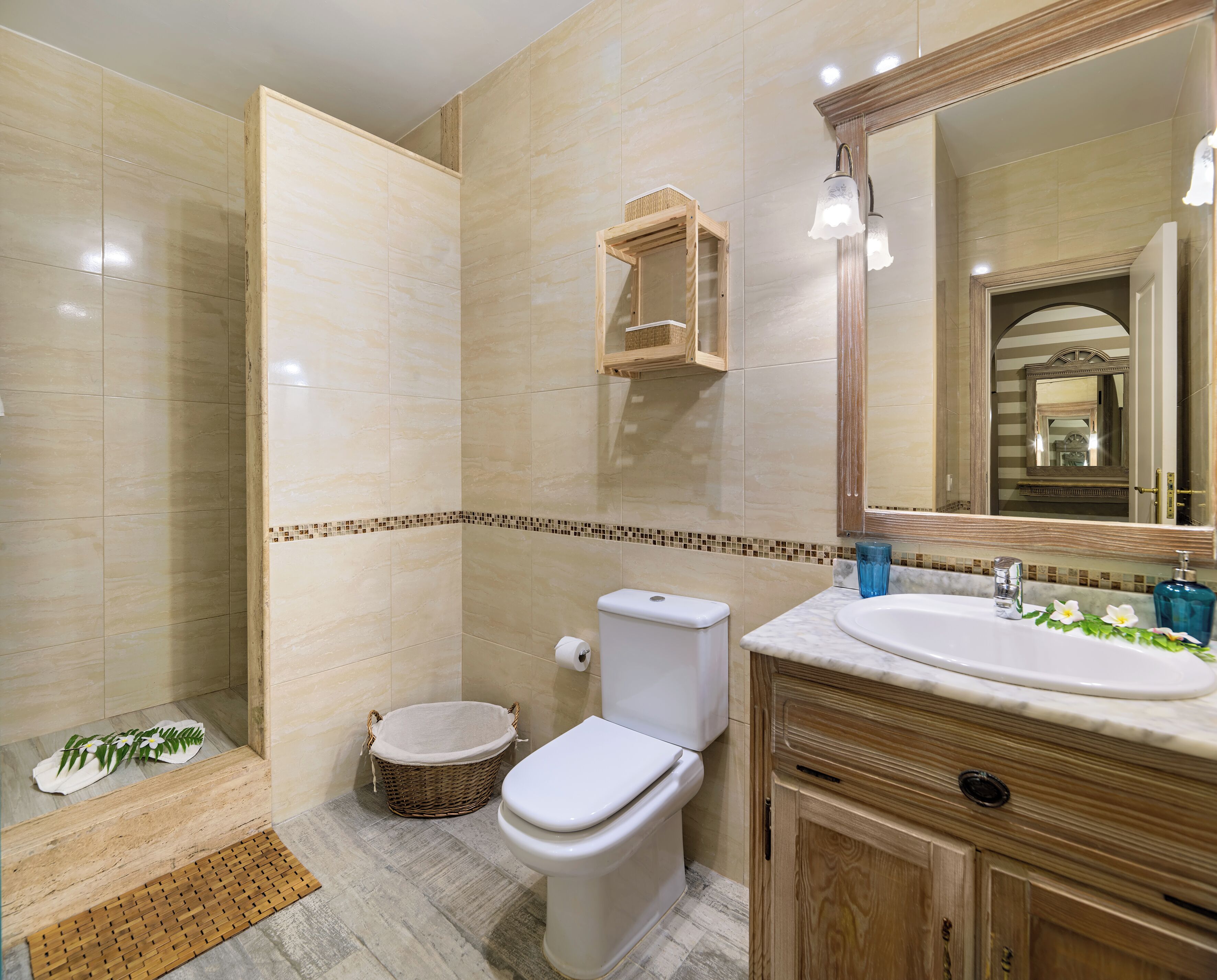 Un bagno con doccia, WC, lavandino e specchio.