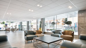 A spacious lobby with modern seating, large windows, and a high ceiling. - Hotel Best San Diego (Salou)