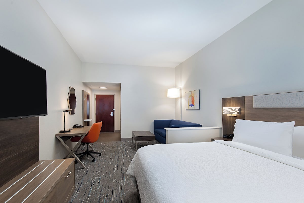 Une chambre d’hôtel équipée d’un lit, d’un bureau, d’une chaise et d’un téléviseur.