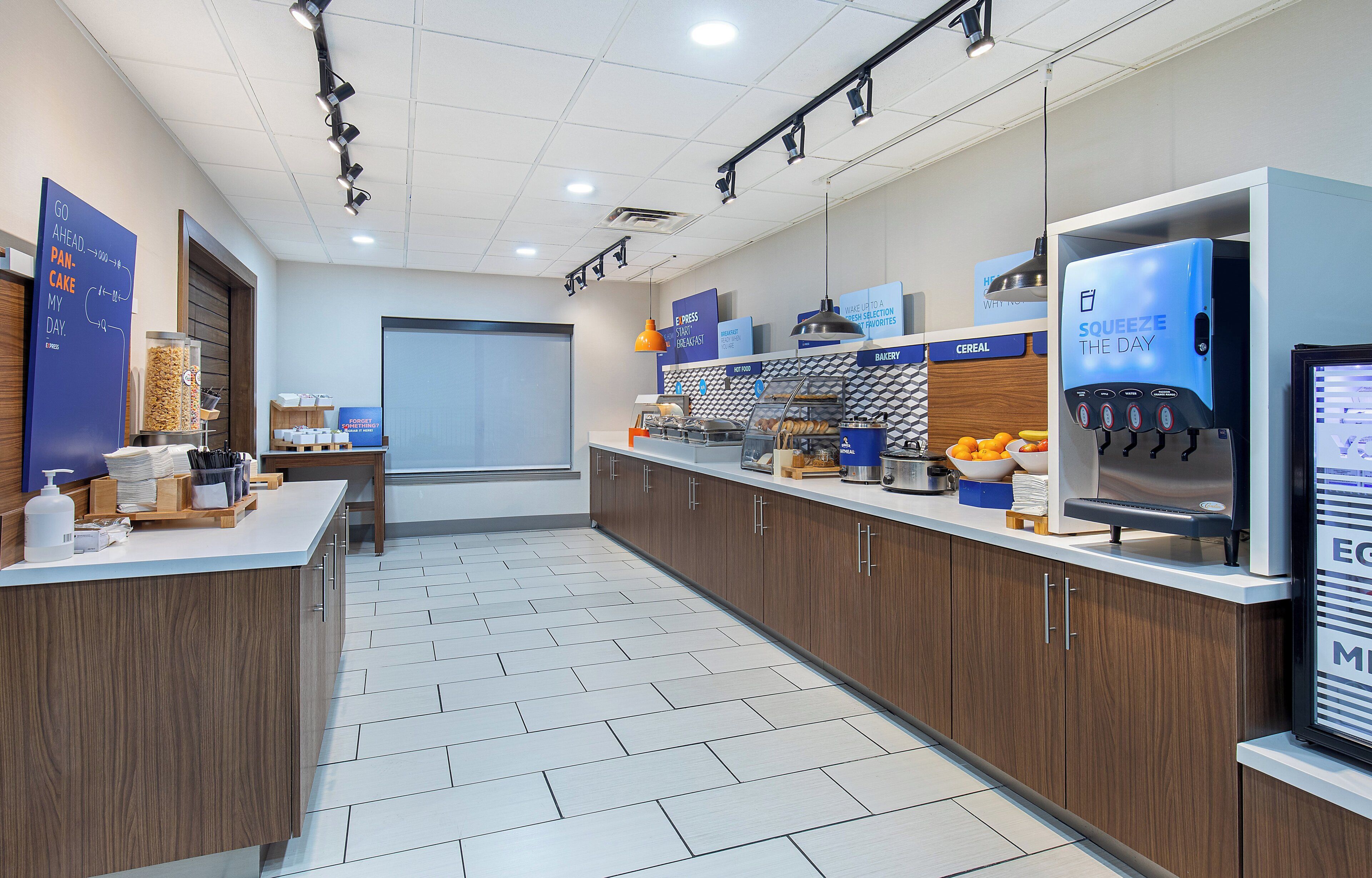 Un espace cuisine moderne comprenant une machine à café, un réfrigérateur et un comptoir avec divers produits alimentaires.