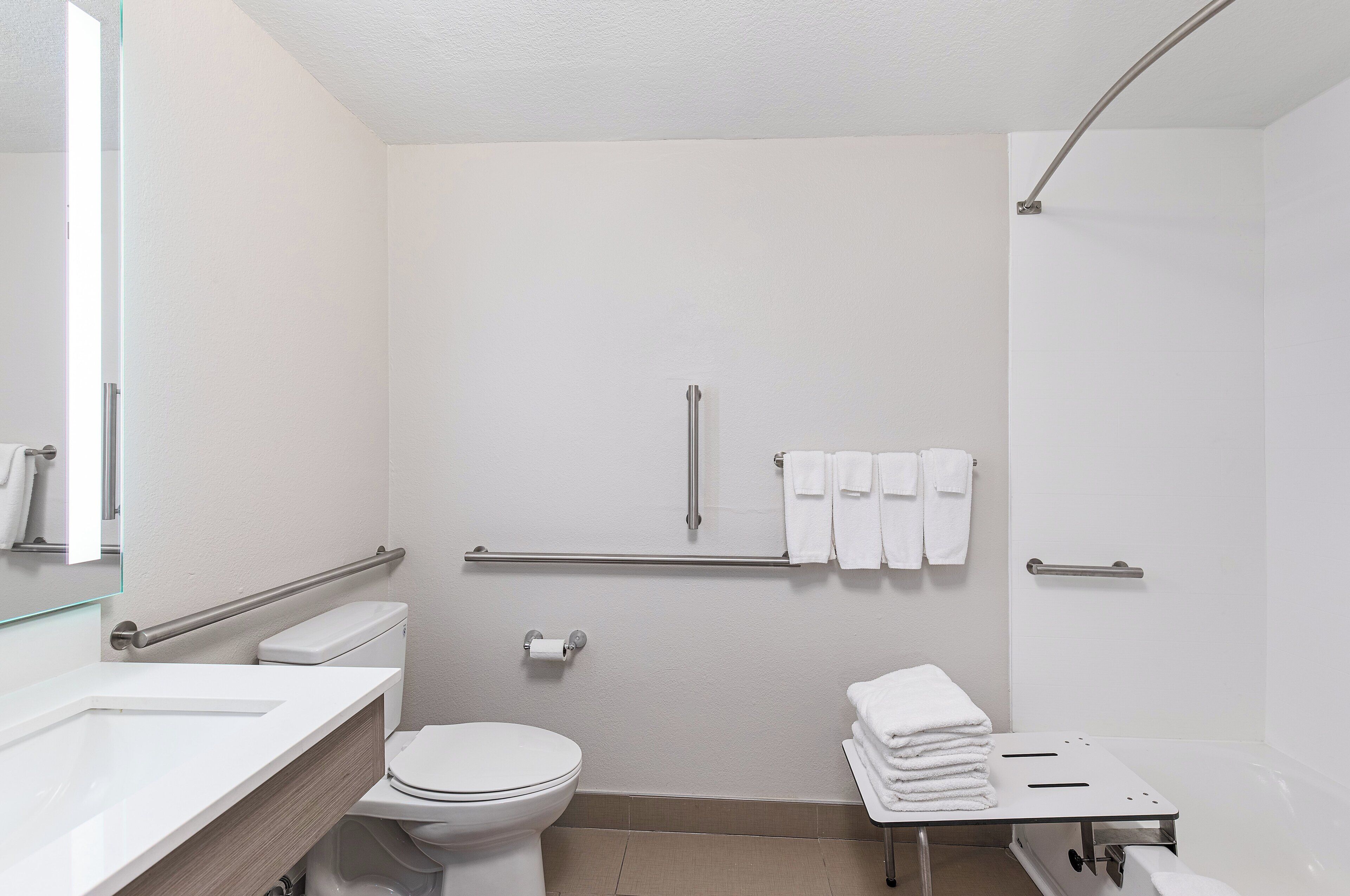 Un baño moderno con inodoro, lavabo y zona de ducha.