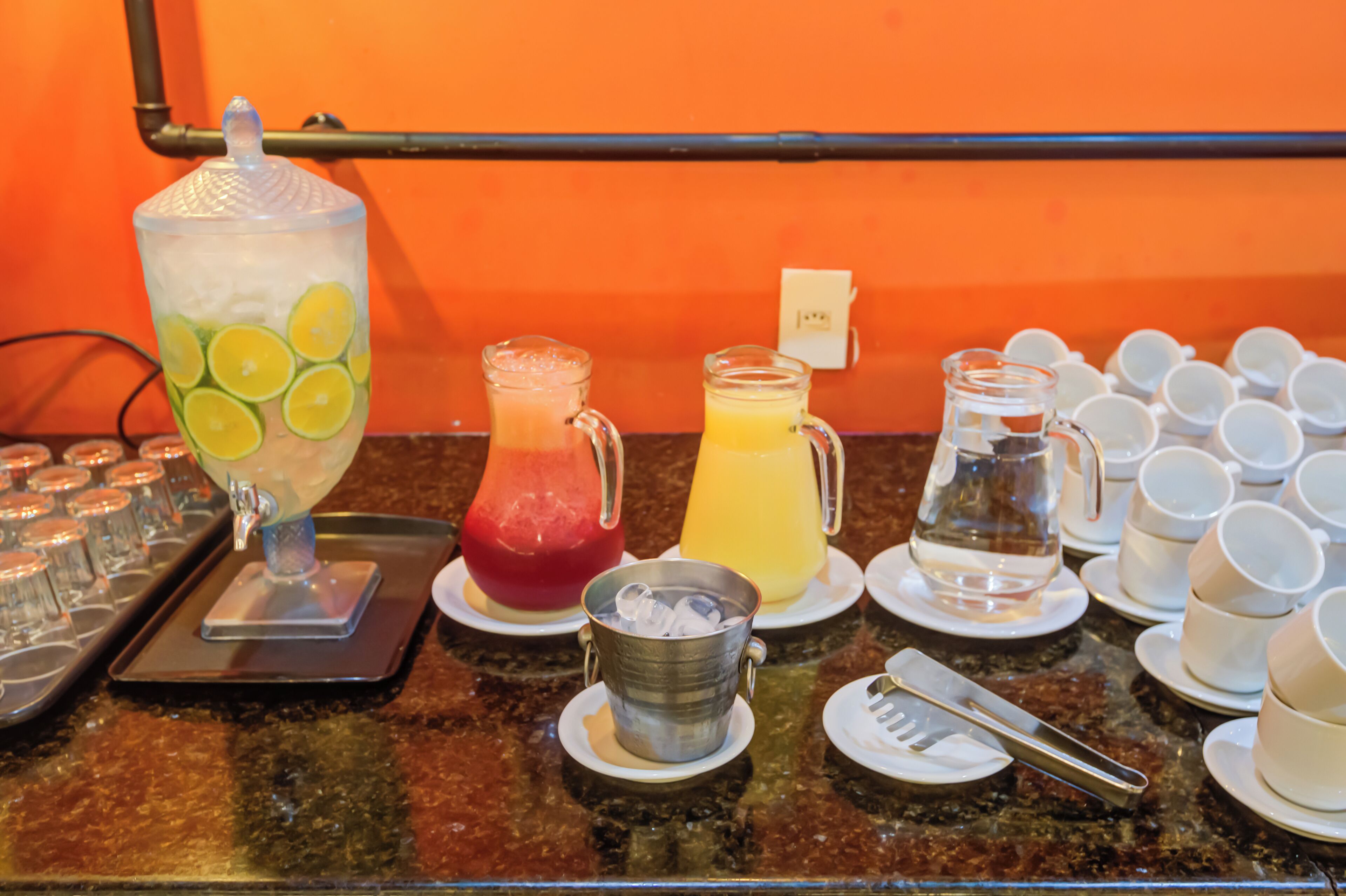 A breakfast bar with various beverages and utensils.