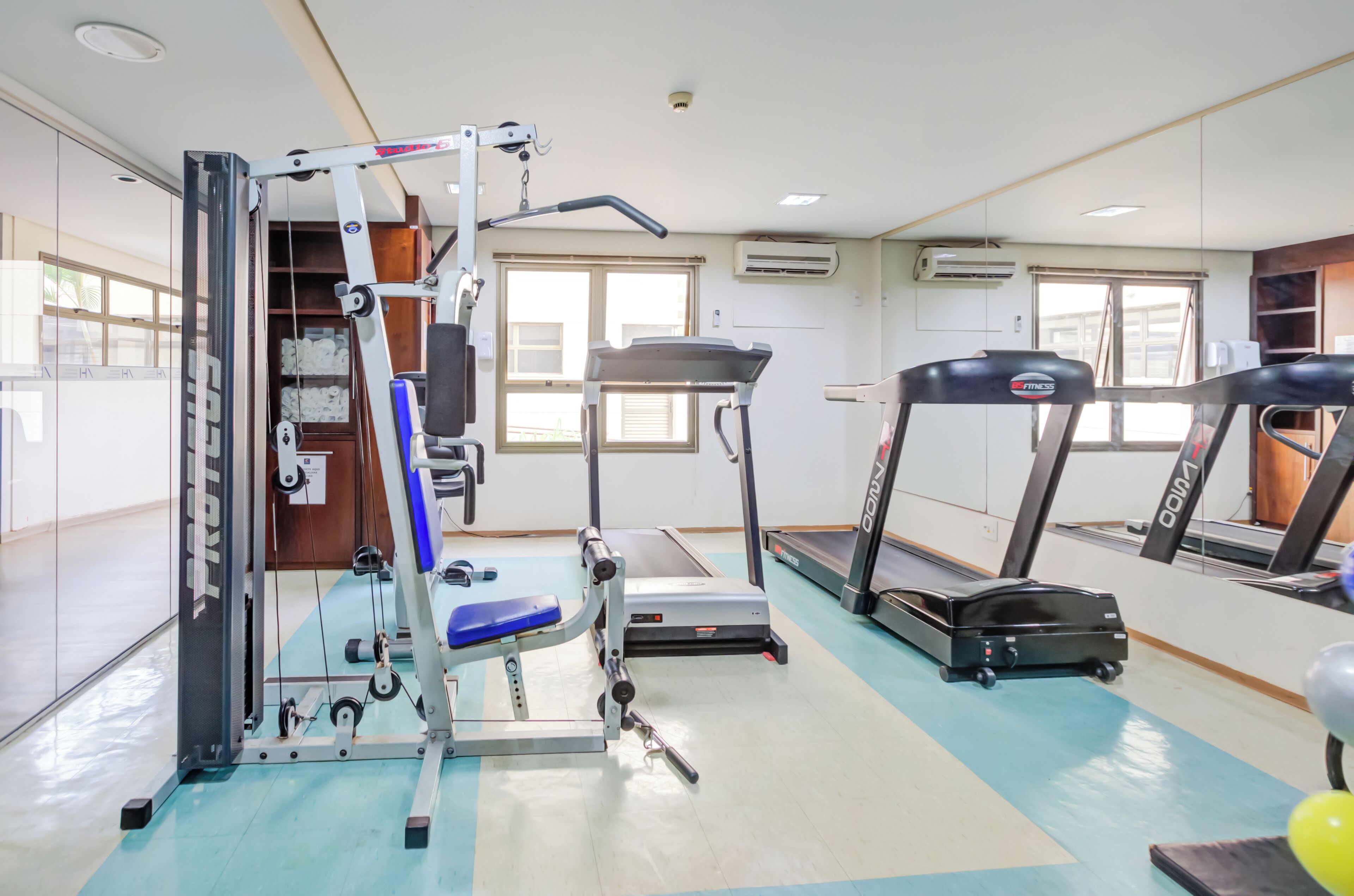 A gym with exercise equipment, treadmills, and a weight machine.
