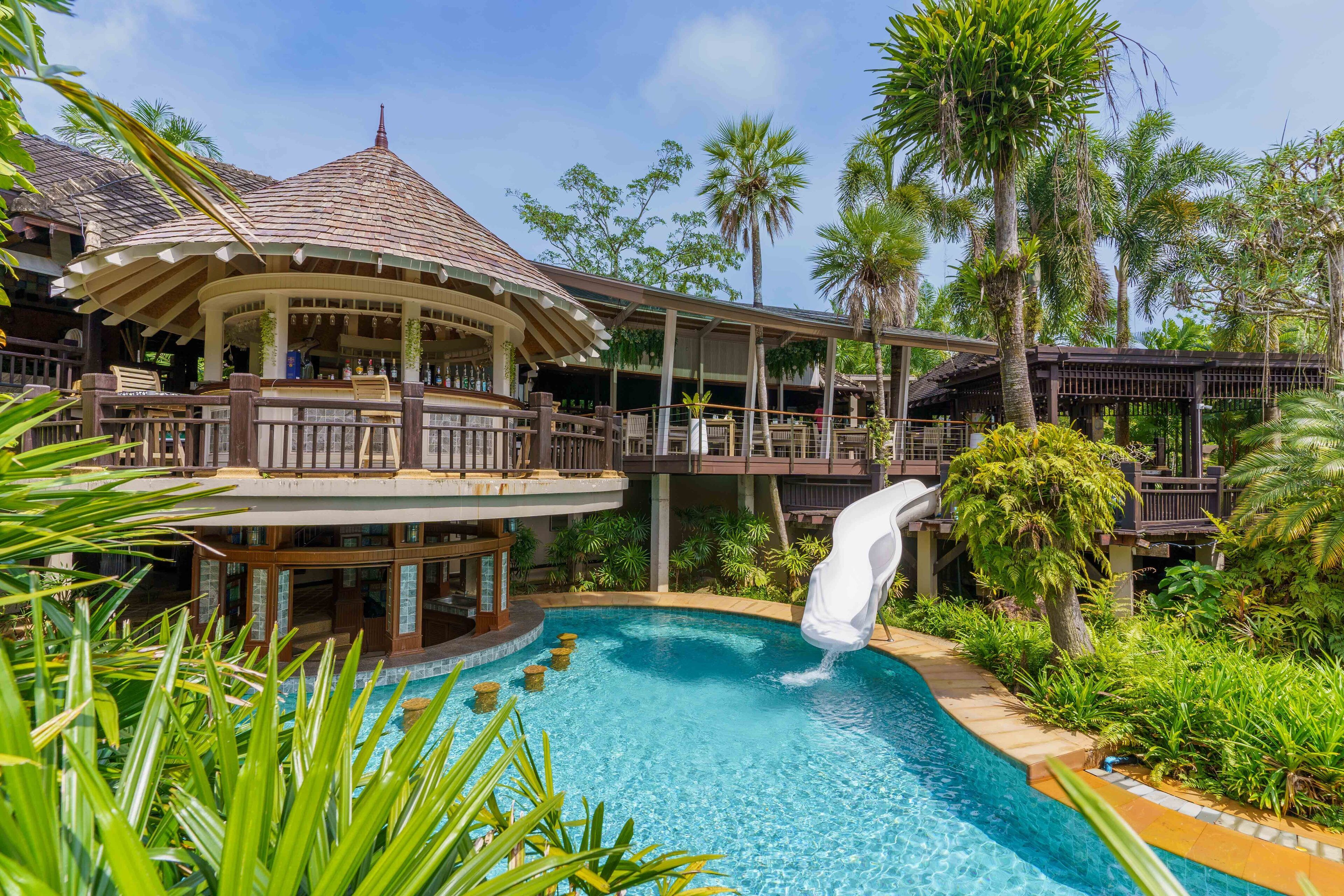 A resort with a pool, a gazebo, and a slide.