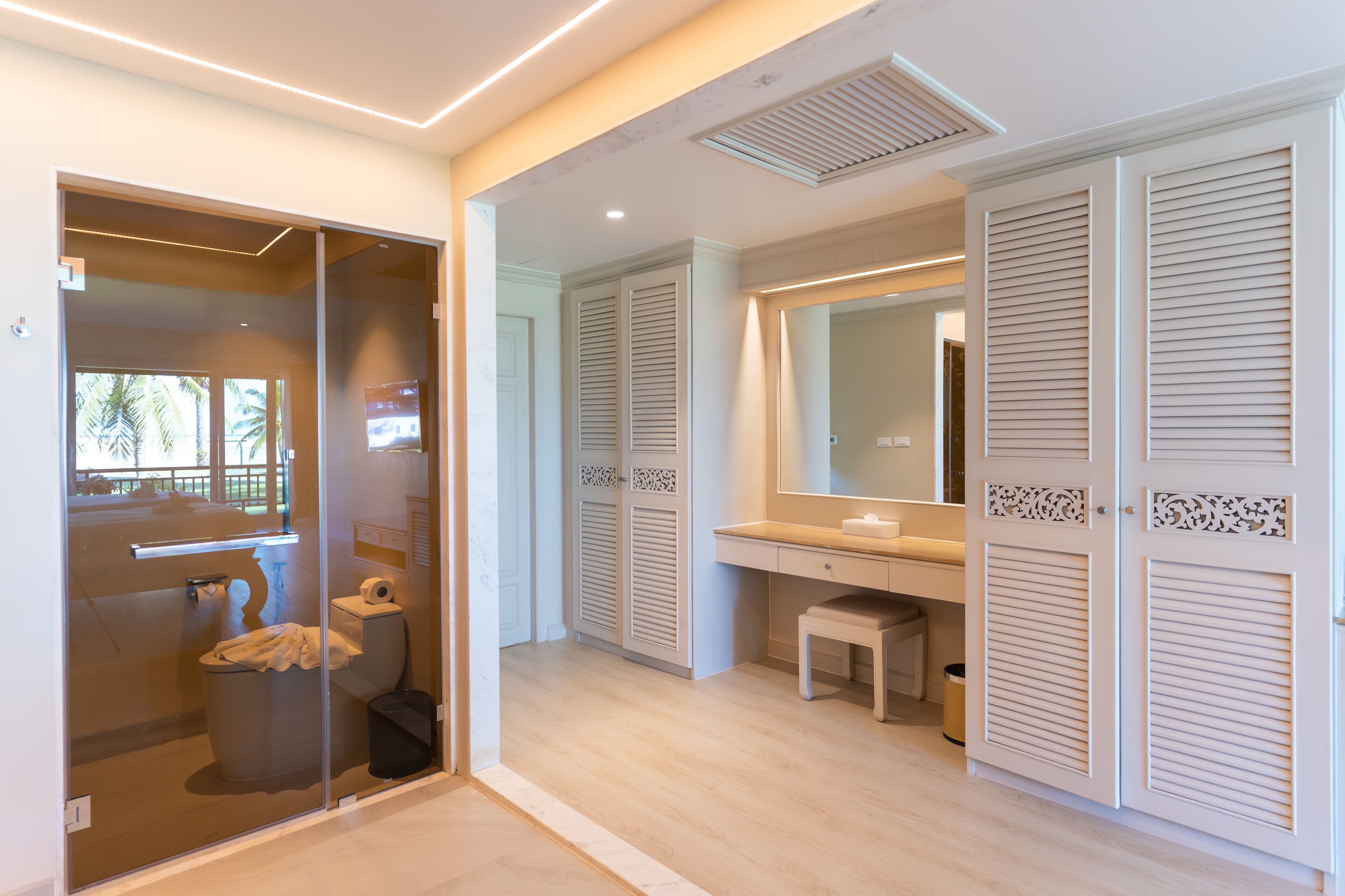 A modern bathroom with a glass shower enclosure, a toilet, and a vanity with a mirror.