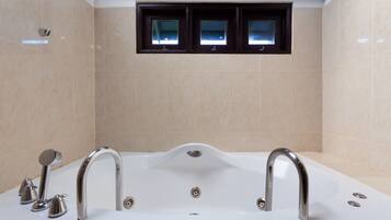 Un baño moderno con una bañera independiente, dos llaves y un cabezal de ducha.