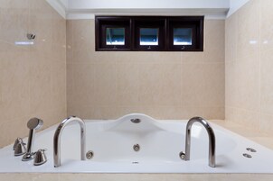 Un baño moderno con una bañera independiente, dos llaves y un cabezal de ducha.