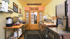 A kitchen with a coffee machine, a bread display, and a private sign above the door. -  Valued Stay Mayflower (Madison)