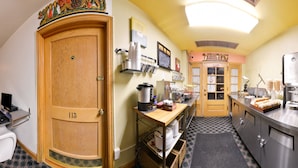 A hotel room with a kitchenette, a dining area, and a private door. -  Valued Stay Mayflower (Madison)