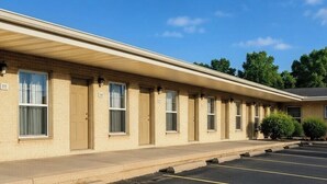 A motel with a row of rooms, numbered 111, and a parking lot. -  Valued Stay Mayflower (Madison)