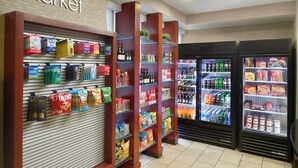 Una tienda de comestibles con estantes llenos de botanas, bebidas y productos envasados.