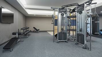 A gym with weight machines, benches, and a punching bag.