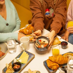 Ein Frühstückstisch mit Croissants, einer Suppenschüssel und einem Glas Orangensaft.