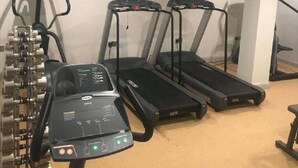 A gym with treadmills, a stationary bike, and a television on the wall. - Maldron Hotel Sandy Road Galway (Galway)