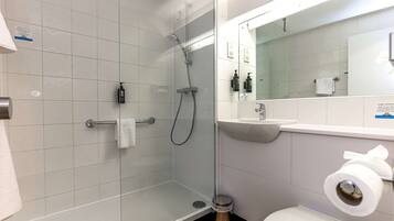 Un baño moderno con ducha de vidrio, lavamanos e inodoro.