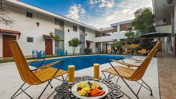 Relax by the pool in our serene courtyard, surrounded by lush greenery and comfortable seating.