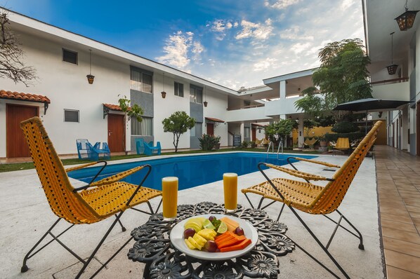 Alberca al aire libre, sombrillas en la alberca y camastros 