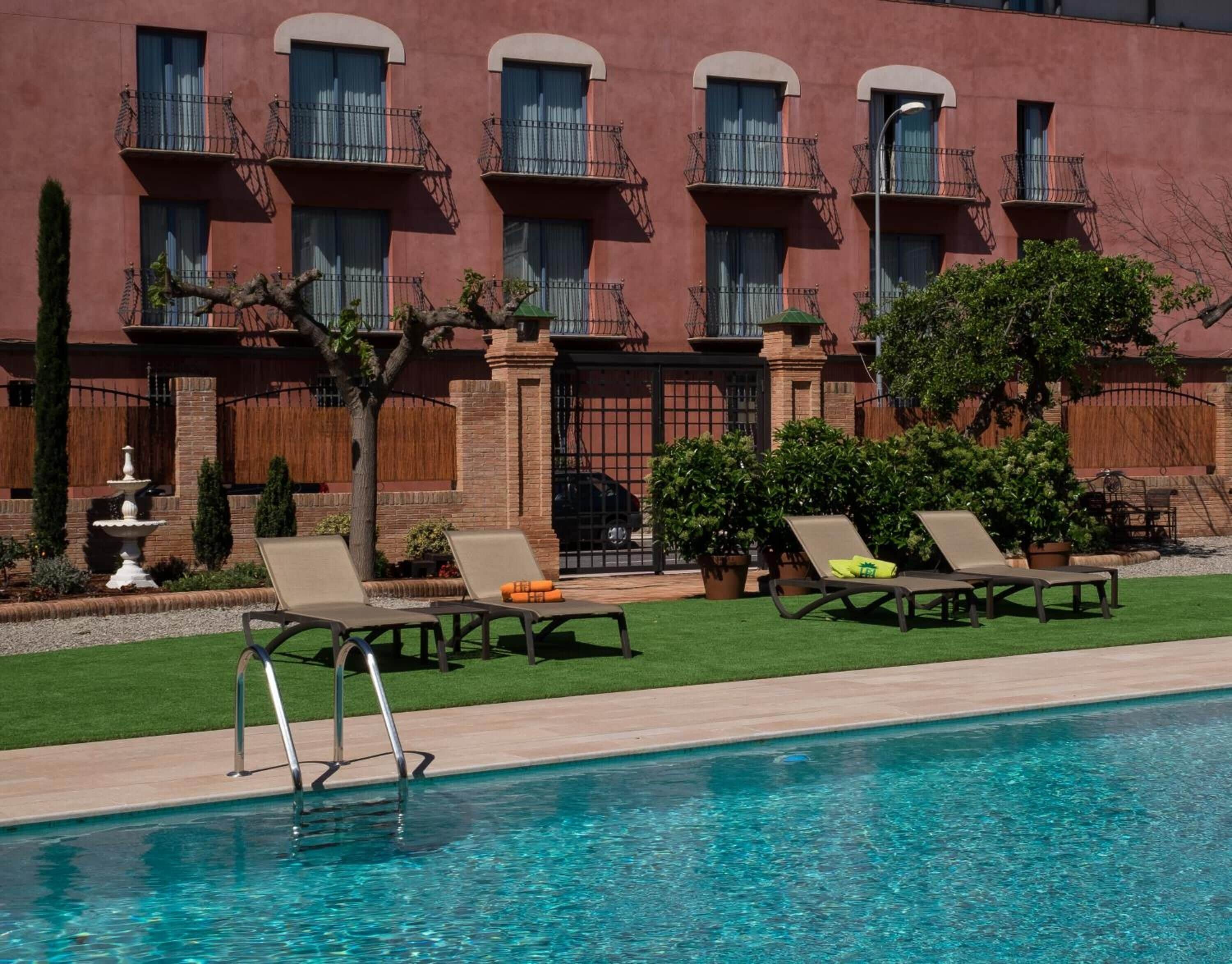 A poolside area with lounge chairs and a fountain.