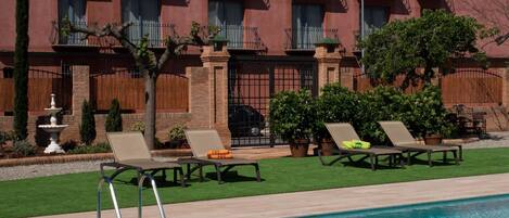 A poolside area with lounge chairs and a fountain.