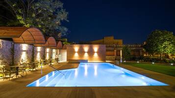 Una piscina al aire libre, tumbonas