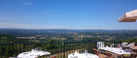 Eine Terrasse mit Essplätzen mit Blick auf eine reizvolle Landschaft.