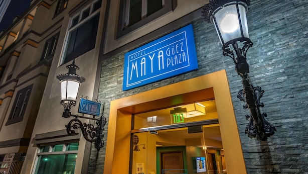 A hotel entrance with a sign reading "Hotel Maya Plaza" and an "EXIT" sign above the door.