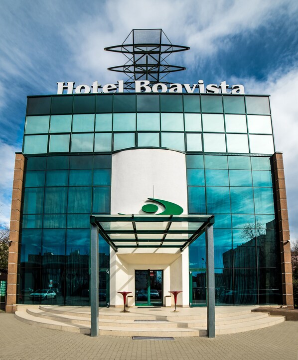 Hotel Boavista with a modern glass facade, a prominent entrance with steps, and a clear sky.