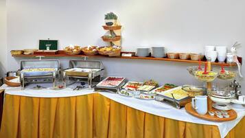 Una mesa de buffet con diversos alimentos y utensilios para servir.