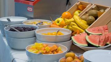 A buffet with various fruits and bowls of food.