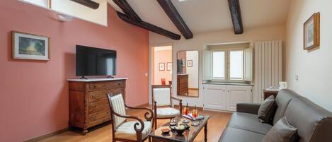 A living room with a television, wooden furniture, a sofa, and a dining table.