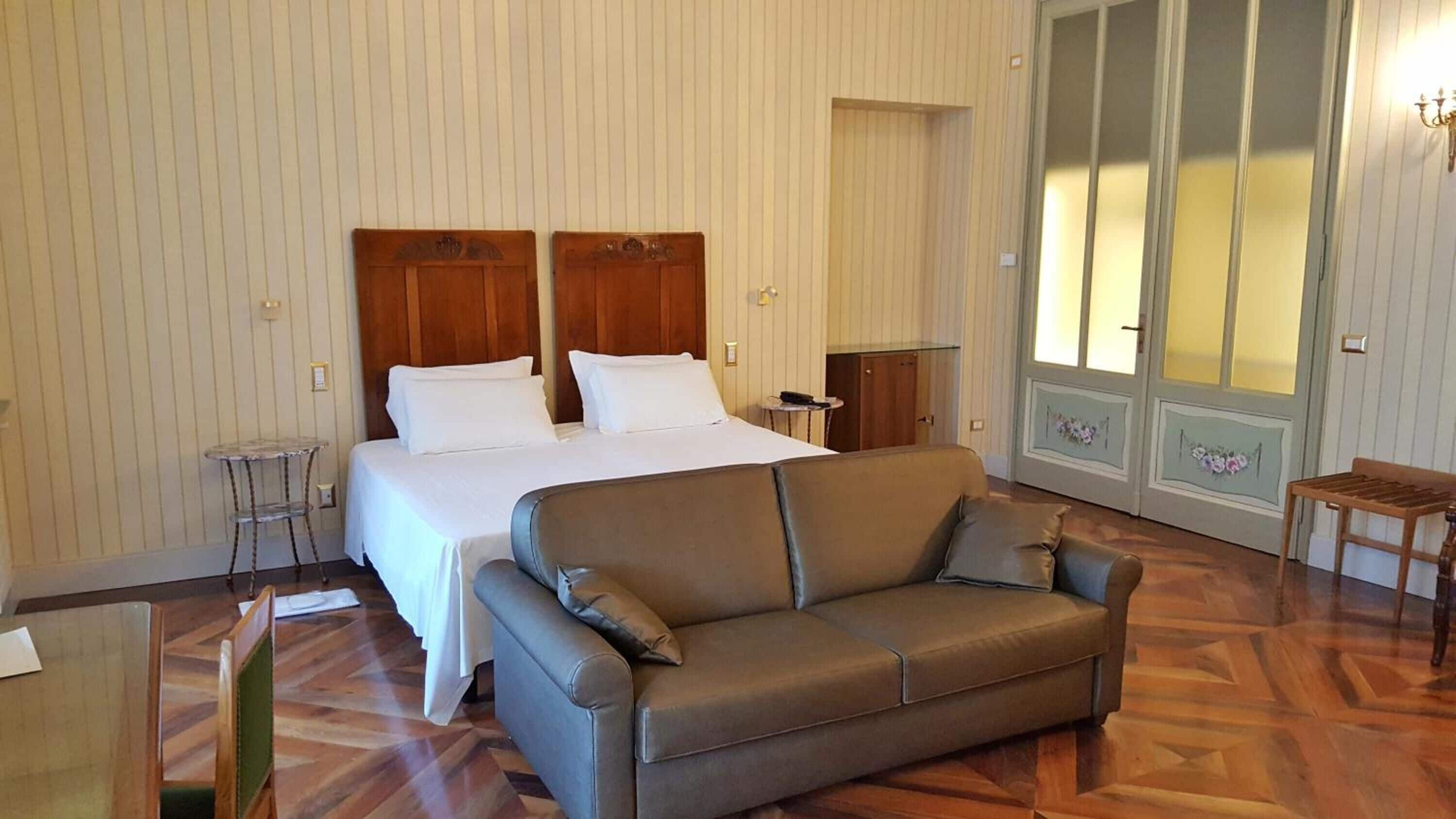 Ein Hotelzimmer mit Bett, einer Couch, einem kleinen Tisch und einem Schrank.